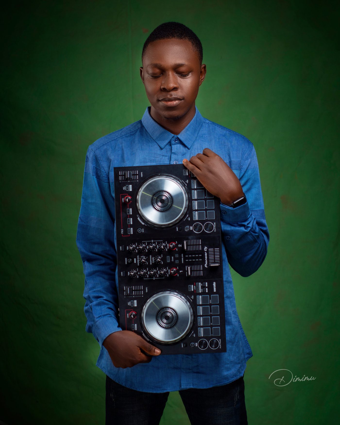 DJ Wealth holding a Pioneer DJ controller